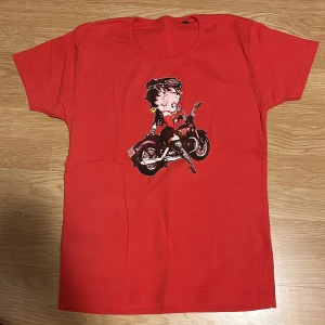 T-shirt - Röd betty boop t-shirt. Storlek L-XL men kan fungera för folk med andra storlekar beroende på hur man vill att den ska sitta. Sitter rätt så fint på mig som annars har S💗