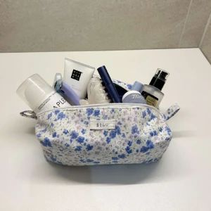 Necessär - Portofino  - Blå småblommig necessär gjord på återvunna textilier! Insida av blå satin för att hindra dra åt sig smink och är tvättbar.🩵💜