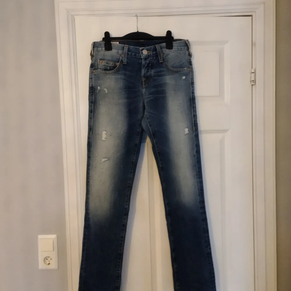Snygga blåa jeans med hål från True Religion i storlek 28 Midjemått: 38cm Innerbenslängd: 81cm Ytterbenslängd: 106 cm Skriv gärna vid frågor!! . Jeans & Byxor.