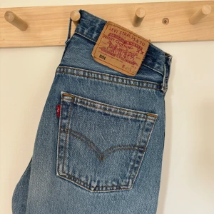 Levi’s vintage jeans 501 xs/s  - Klassiska 501:or i den perfekta mellanblå tvätten. Fint vintage skick. Läderlappen där bak har lossnat på ena sidan. Annars är skicket väldigt bra! Inget slitage insida lår tex som det brukar kunna vara. Waist 29 men mer som dagens 26 . 