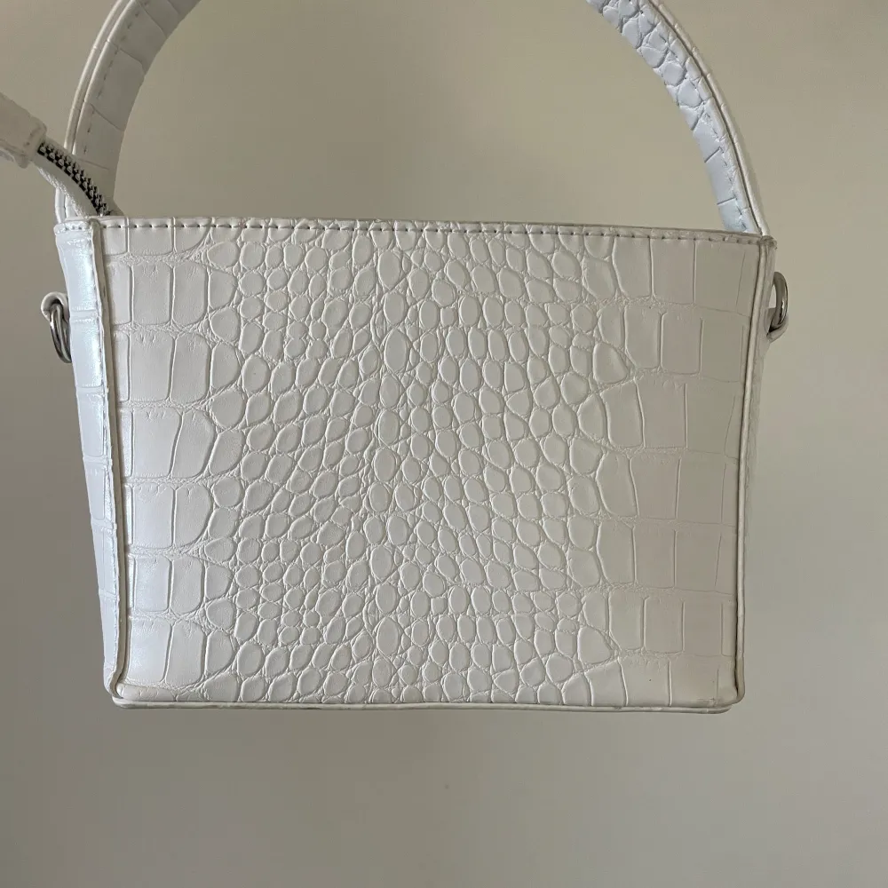 Säljer denna vita handväska 🤍 fin kvalité, kommer endast med det korta bandet till . Väskor.