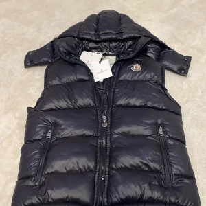 Moncler väst - Hej! Jag säljer min Moncler väst pga ska köpa en ny. Inga skador på västen inget fel allt e perfekt som det ska va!