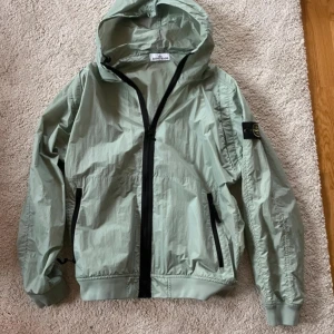 Stone island vindjacka - Armygrön colorway men är mer av en ljusgrön/turkos färg. Storlek XL, men den sitter som en L. Använd två gånger så i princip helt ny. Köpt från Selvage. Felproducerad qr kod som ej visar rätt, fick den därav för ett billigare pris och säljer billigt
