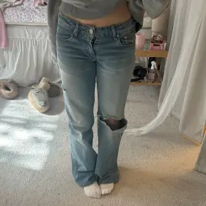 Så fina lågmidjade jeans med slitningar!! Midjemått rakt över är 34cm och Innebenslängden är 71 cm!🩷🩷🩷