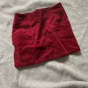 Lågmidjad kjol - Säljer denna röda lågmidjade Manchesterkjolen som tyvärr är för liten för mig. Midjemåttet är ca 36 cm och kjolen är ca 34 cm lång💕 