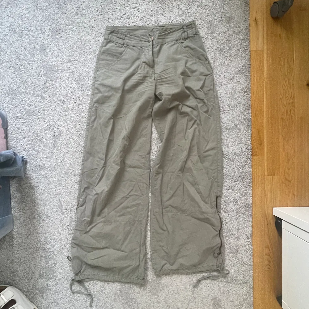 Gröna Khaki parachute pants / cargo / vida byxor från Isabell Kristensen. I bra skick, storlek 34 :) Dragkedja och knutdetalj på benen. . Jeans & Byxor.