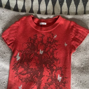 Klänning/tröja - Kort klänning/lång tröja, jag brukar ha den över ett par kostymbyxor! Orange med silvriga och svarta detaljer. Lite nopprig längst ner (som syns på bild 3) men annars i väldigt fint skick!