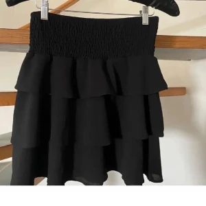 Svart volangkjol  - Säljer en jätte fin volangkjol i storleken M med passar som en, den är andvänd fåtal gånger med den är i super bra skick, det säljs inte längre🩷