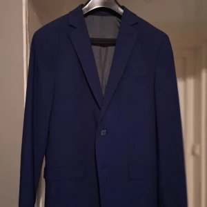 Kostymset - Kavaj: Storlek 48 Regular fit Byxor: Storlek 33/32 Slim fit Skjorta: Storlek 39/40 (M) Slim fit (Kan köpas separat, skriv vid eventuella prisförslag) Använts endast en gång och tvättats två gånger. Köpt på dressman för ungefär 1700 kr