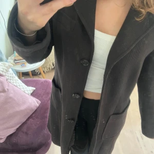 Fin långkappa. Mörkbrun/svart. (Inga fläckar de är spegeln)  - Mörkbrun/svart långkappa. Perfekt till våren! Den är från Espirit och är i storlek S. Ullkappa i fint skick förutom att de är hål i innetyget som du ser på bilden. Men de går väldigt snabbt att sy ihop ihop och syns inte när man har på sig den!🌺