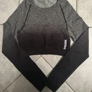 Träningstopp  - Säljer denna träningstoppen från Gymshark då jag aldrig använt den. Fint skick och jättefin. Jag är 169cm och toppen går till precis över naveln. 