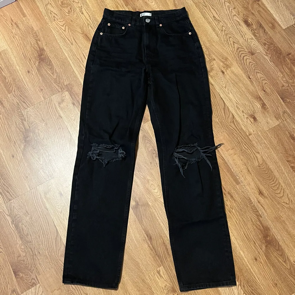 Ett par svarta 90s tall jeans med hål på knäna från Gina Tricot, storlek 36. Använda fåtal gånger och passar bra i längden på mig 178 cm lång 🩵. Jeans & Byxor.