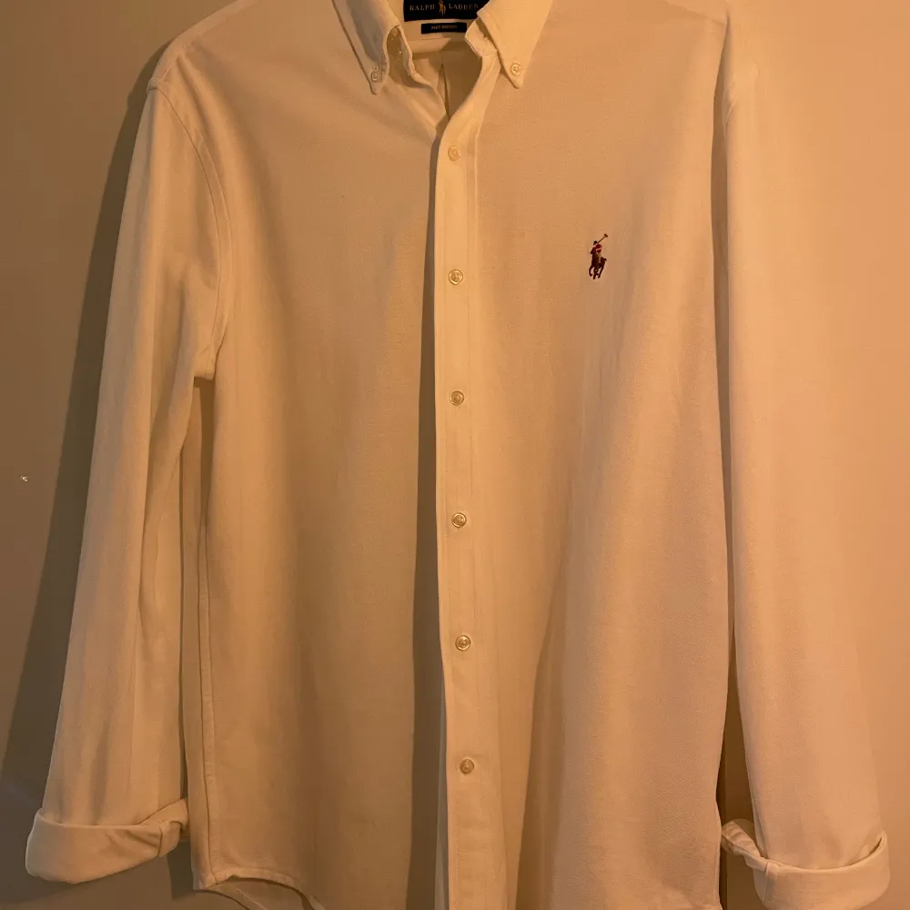 Denna tunna knit oxford polo skjorta är perfekt till en varm sommardag. Den är oanvänd och är i storlek L men sitter som M. Nypris på denna är ca 2000kr. Har du några frågor är det bara att skriva. Skjortor.