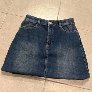 Snygg jeanskjol - Kjol som trender till sommarn i fint marinblått jeanstyg, från Lindex och i bra skick, använd fåtal gr o skick som ny. Tvätta självklart innan den skickas💕 Samm fraktar ifall man köper nått mer💓