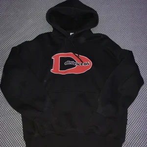 District 46 Hoodie - En riktigt cool hoodie från District 46 från Junkyard. Knappast använd då den var för kort för mig. Storleken är S men den är rätt oversized så den kommer att passa som Medium.