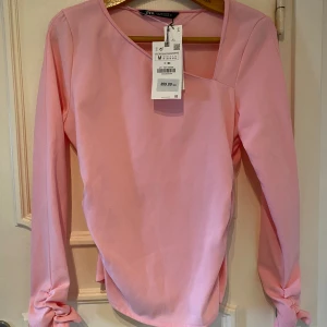 Ny ljusrosa blus, M  - Elegant rosa blus stl M, ny med prislapp kvar. Figurnära.   Nypris 359 kr, mitt pris 200 kr.   Skickas mot fraktkostnad 
