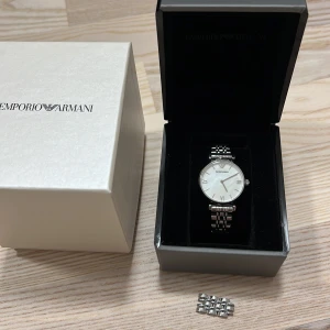 Armani klocka - Silvrig damklocka ifrån Armani. Använd fåtal gånger, så mycket fint skick. Precis bytt batteri. Medföljer liten länk för att kunna göra klockan större. 