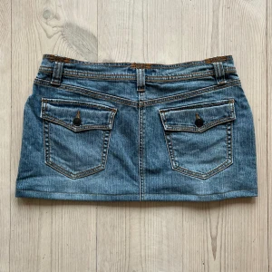 Lågmidjad jeanskjol  - Ljusblå lågmidjad jeanskjol från Daisy Fuertes som jag har sytt upp från en längre kjol. Står storlek 8 och passar som en M. Tvärs över midjan är det 41 cm och längs med sidan är det 29 cm. Fint skick. Använd gärna köp nu!