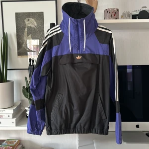 Adidas original jacka - Jacka i nyskick från Adidas. Flerfärgad med hög hals och ficka på magen samt sidorna.  Storlek: XS 