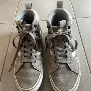 Gråa Vans perfekta till hösten/vintern - Klassiska gråa Vans i hög modell. Använda men i bra skick. Strl 38 (7,5)
