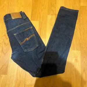 Nudie Jeans  - Säljer ett par Nudie jeans i fint skick med ett litet hål vid låret som man kan se på bild 1. Modellen är tape Ted och sitter ganska likt grim Tim. Skriv om ni har några frågor😁