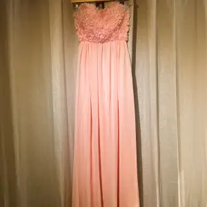 Superfin rosa långklänning med blommor upptill. detaljer i ryggen. klänningen är helt ny med prislapp på! Jag är 165cm lång och den släpar lite på marken. köparen står för frakten🙌🏼❤️