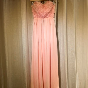 rosa blommig balklänning/långklänning  - Superfin rosa långklänning med blommor upptill. detaljer i ryggen. klänningen är helt ny med prislapp på! Jag är 165cm lång och den släpar lite på marken. köparen står för frakten🙌🏼❤️