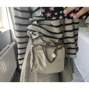 Stella McCartney väska tiny  - Säljer min Stella McCartney väska som inte kommer till användning. Den är tyvärr lite trasig vid magneterna som ska hålla ihop väskan men går att lämna in eller fixa hemma (kom privat för bild).  Pris kan diskuteras💕