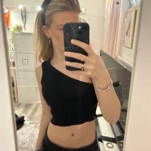 Svart topp - En kort ribbad one-shoulder topp från NAKD som tyvärr blivit för liten för mig!