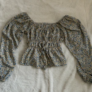 Blommig tröja - Blommig tunn tröja från Shein. Långärmad med en knut framme. Tröjan är väldigt stretchig och har knappt används. Storlek S men passar M tack vare stretchen 