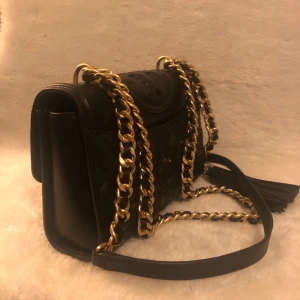 Tory Burch väska - Säljer tory burch fleming convertiable shoulder bag/axelremsväska. Den är som ny, använd vid cirka 3 tillfällen i somras. Fick den sommaren 2023 och den har bara legat i garderoben sedan dess. Nypris 8 265 kr. Så du som köper gör ett riktigt kap.