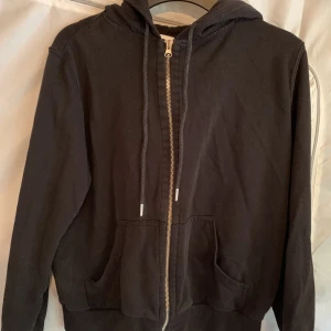 Hoodie - En enkel men fin hoodie med huva och dragkedja. Strl M, men lite mindre i storleken. Funkar på en M om man vill ha en lite tajtare passform dock!