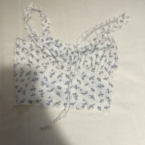 Blommigt kort linne - Det är ett fint blommigt linne som passar bra till en kjol eller så. Köpte för runt 60 men har inte användning för den. Storlek S