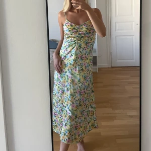 Blommig klänning - Blommig klänning från stradivarius i strl 36. Vadlång och djupare i ryggen i sidenliknande material. Nypris 399:- 
