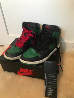 Jordan 1 high Pine green 2.0 Stl. 41 - Säljer dessa snygga Jordan 1s. De är köpta för ca 2 år sen från GOAT för 3800kr. Skorna är ganska slitna och de har en hel del heeldrag. Därav priset. Det finns både röda och svarta snören. Pris ej hugget i sten. Bra pris vid snabb affär.