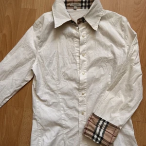 Burbbery skjorta - Vit burberry skjorta. Ser ut som ny om man stryker den. Skriv om ni har fler frågor.