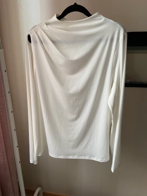 Affection topp - Långärmade tröja med slit vid ena axeln och två knappar i nacken. Nyskick, använd en gång.