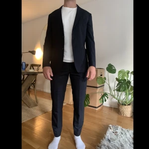 Kostym - These glory days  - Marinblå kostym, både kavaj och byxor. Den är väldigt tunn i tyget så den går bra att ha på sommaren. Som linne fast mer dressad. Sparsamt använd så den är i gott skick. 