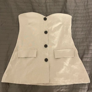 Tubtop - Superfin tubtop med knappar. Fickorna är fejkfickor och knapparna går ej att knäppa upp. Den är stretchig. 