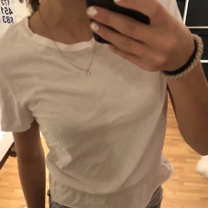 T-shirt  - En jättefin vit tshirt med en rem nertill! Storlek xs 