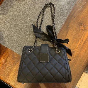 Svart söt väska  - En jättesöt svart väska som är oanvänd och har kvar sitt plast på metall biten som tas bort vid användning. Köparen står för frakten ❤️ 