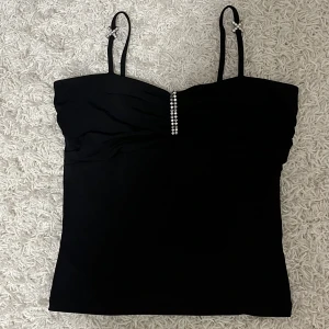 Svart topp - Svart topp med fina detaljer. Storlek S. Stretchigt tyg. Inga bilder på då den är för liten för mig. 