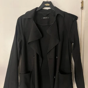 Kappa  - Svart kappa från Gina Tricot. Använd under en årstid. Den är i ett helt skick