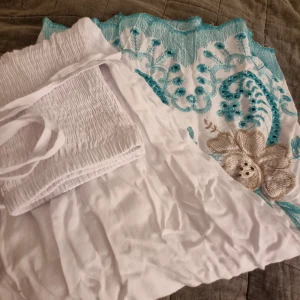 Långkjol blå vit - Otroligt fin vit långkjol som är köpt utomlands. Den har aldrig kommit till andvändning så därför har den inga defekter alls och är som helt ny köpt! Kan även andvändas som klänning ifall man knytrr banden runt halsen❤