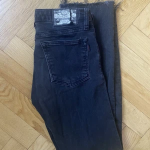 Low waisted jeans - Gråa avklippta jeans. Sitter tight med en liten flare. Inga egentliga defekter förutom lappen bak på första bilden. Lite sliten look.