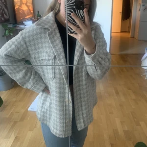 Höst/vårjacka - Höst/vårjacka för de lite kyligare tiderna. Väl använd. Någon tråd som sticker ut (enkelt fixat genom att trä den igenom). Färgen är melerad i grått och vitt men går lite åt det blå hållet på det gråa. 