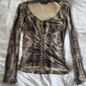 Långärmad tröja - Jätte kattig långärmad tröja i mönster med snörning. Bra skick och sitter snyggt.