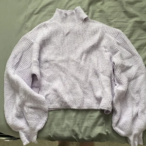 Stickad tröja - Stickad lila tröja från Gina Tricot med vänster axel öppen och lite puffiga armar! Använd och lite nopprig! 💜
