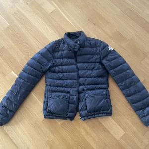 Moncler jacka Lans - Superfin mörkblå moncler jacka i modellen Lans. Jag har använt den rätt mycket men har varit försiktig så den är i mycket fint skick! Nypris ca 8000kr. Kontakta för fler bilder, kan även skicka bild på kvitto för äktehetsbevis❤️