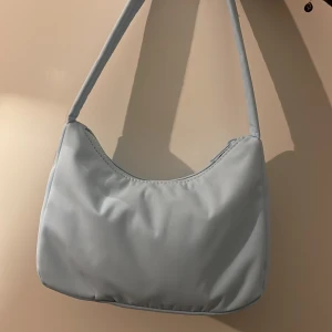 Blå väska  - En ljusblå liten handväska, använd fåtal gånger 